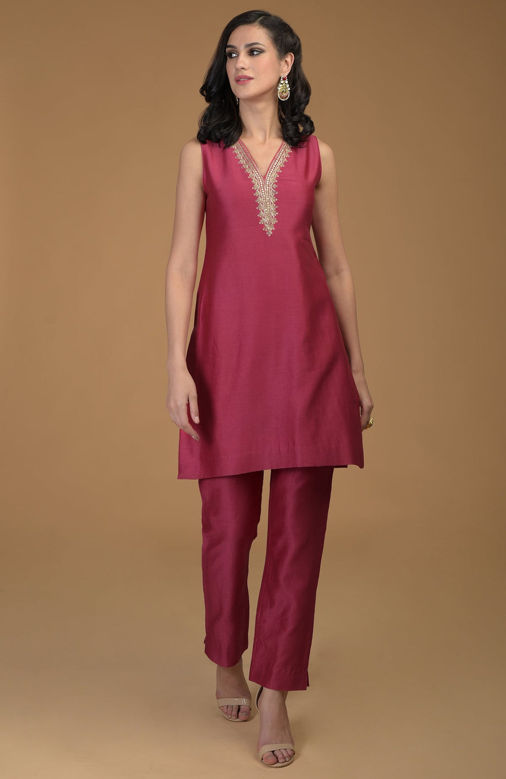 Ruby red two-piece suit with gold zardozi hand embroidery on the kurta neckline.