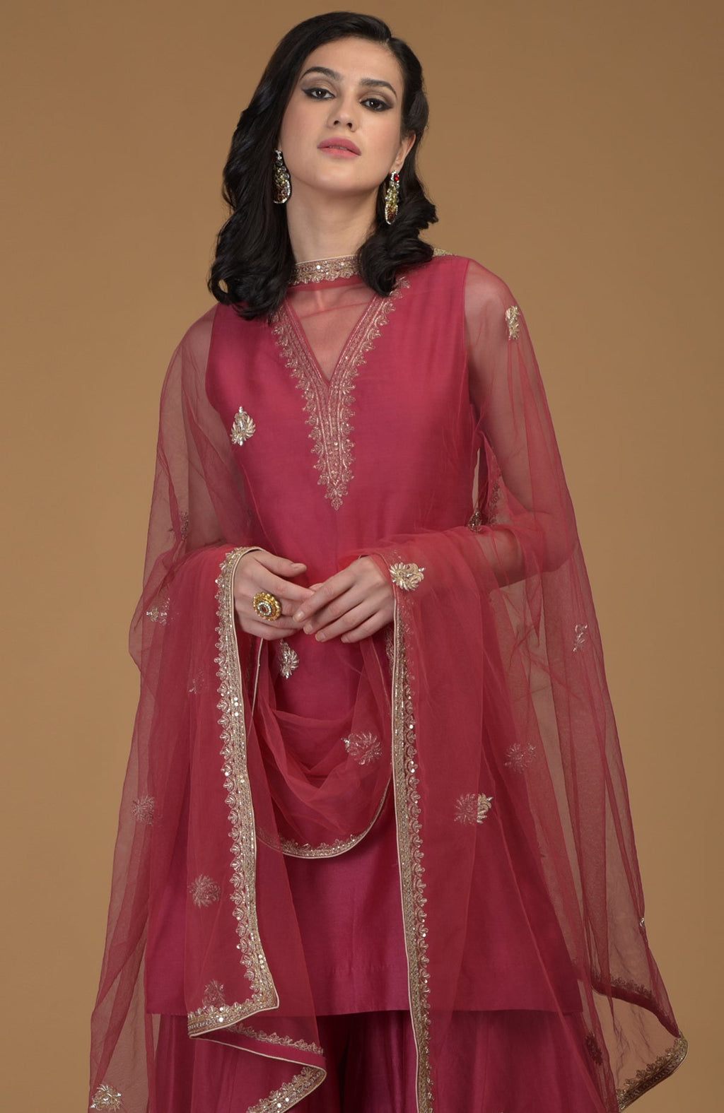 Ruby red zardozi hand embroidered gharara suit with a sheer dupatta.