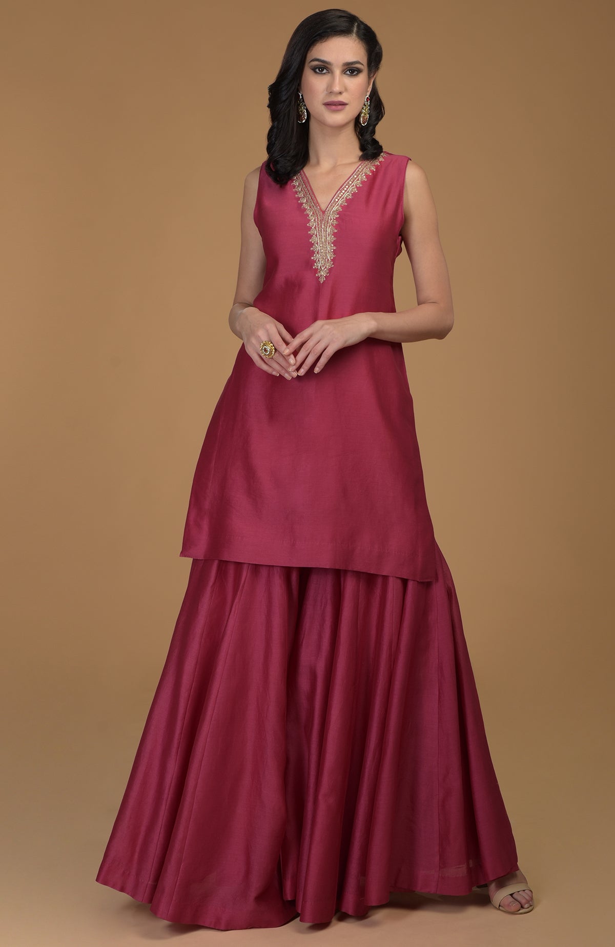 Ruby red zardozi hand embroidered gharara suit with a sleeveless tunic and wide-leg pants.