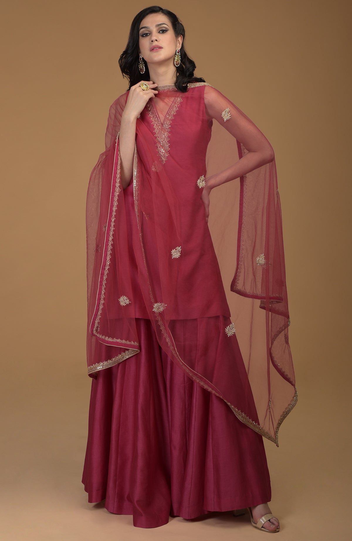 Ruby red zardozi hand embroidered gharara suit with a sheer dupatta.