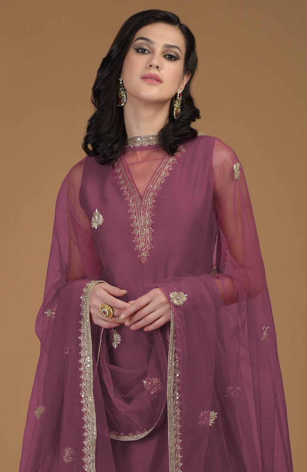 Burgundy purple gharara suit with gold hand-embroidered zardozi on neckline and dupatta.