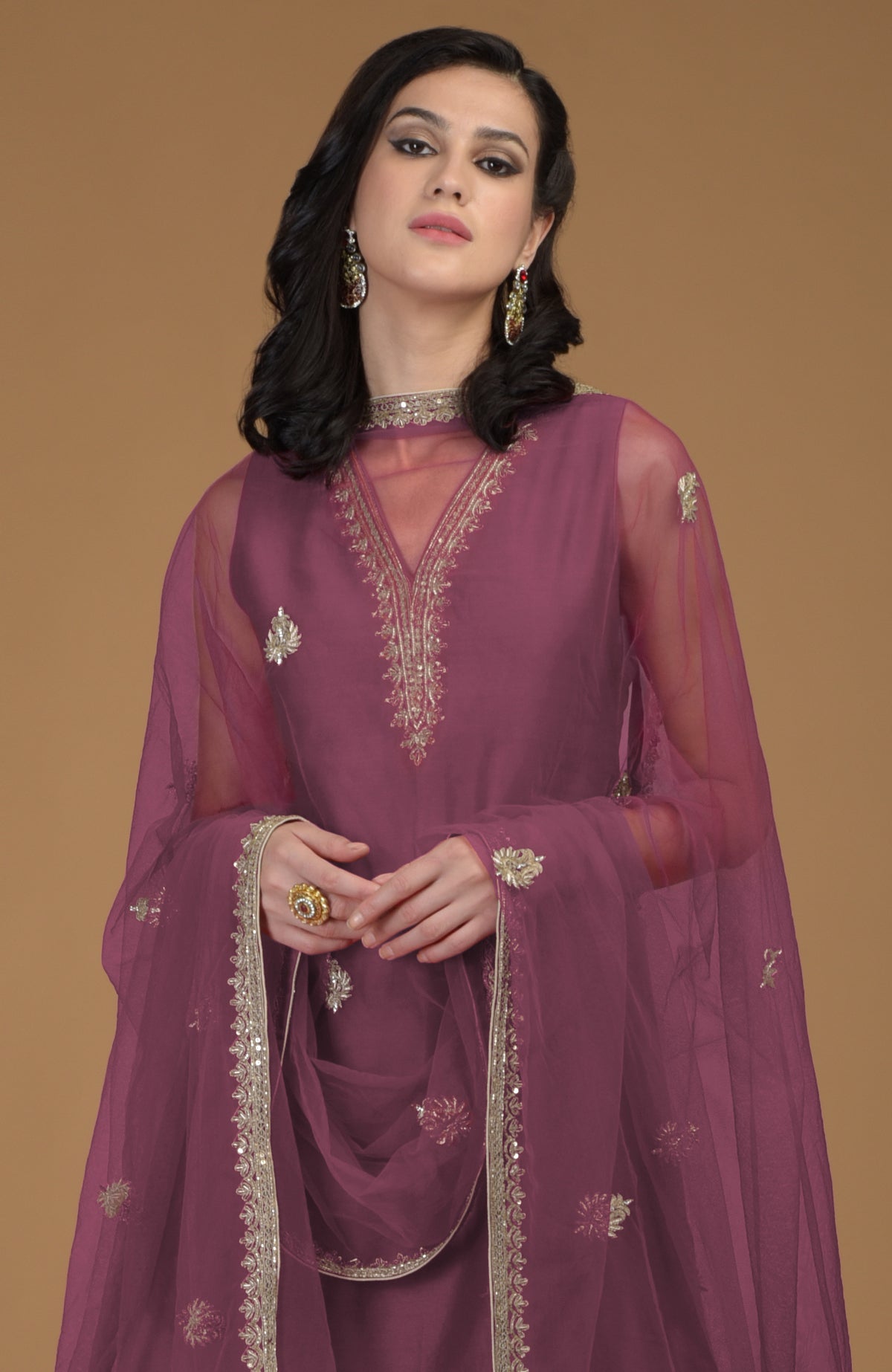 Burgundy purple gharara suit with gold hand-embroidered zardozi on neckline and dupatta.