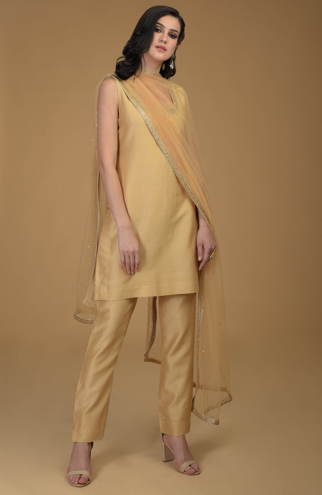 Nude gold zardozi hand embroidered suit with a sleeveless kurta, pants, and dupatta.