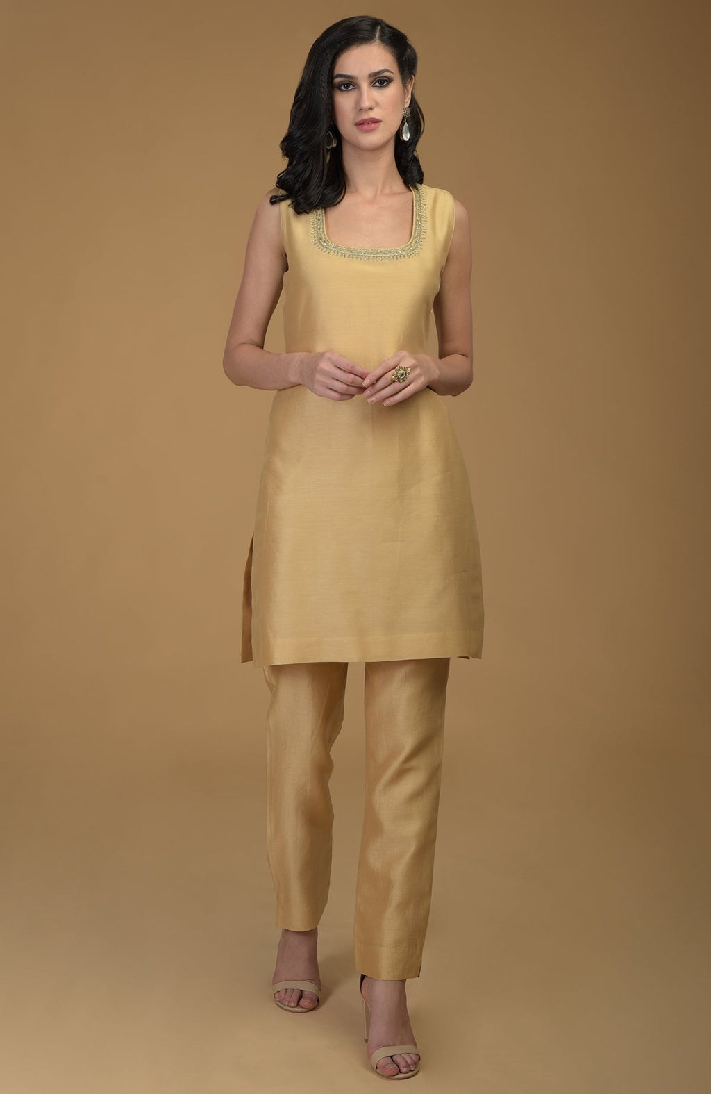 A woman models a nude gold two-piece suit with zardozi hand embroidery.