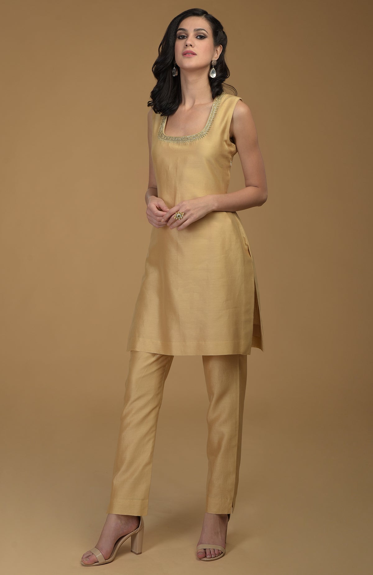 A woman models a nude gold two-piece suit with zardozi hand embroidery.