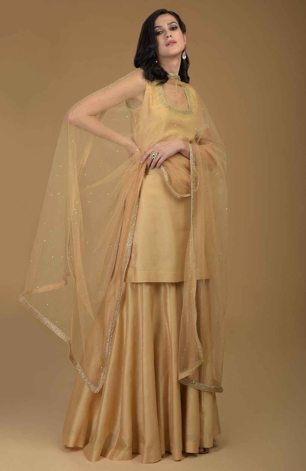 Nude gold zardozi hand embroidered gharara suit with a sheer dupatta.