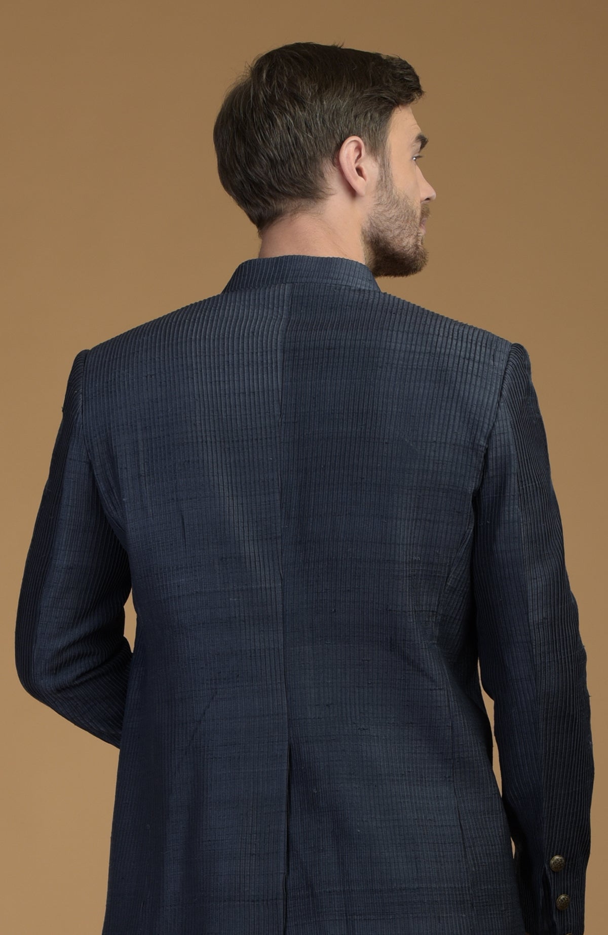 Rear view of a man wearing an Orion Blue Pintuck Raw Silk Bandhgala Jacket.