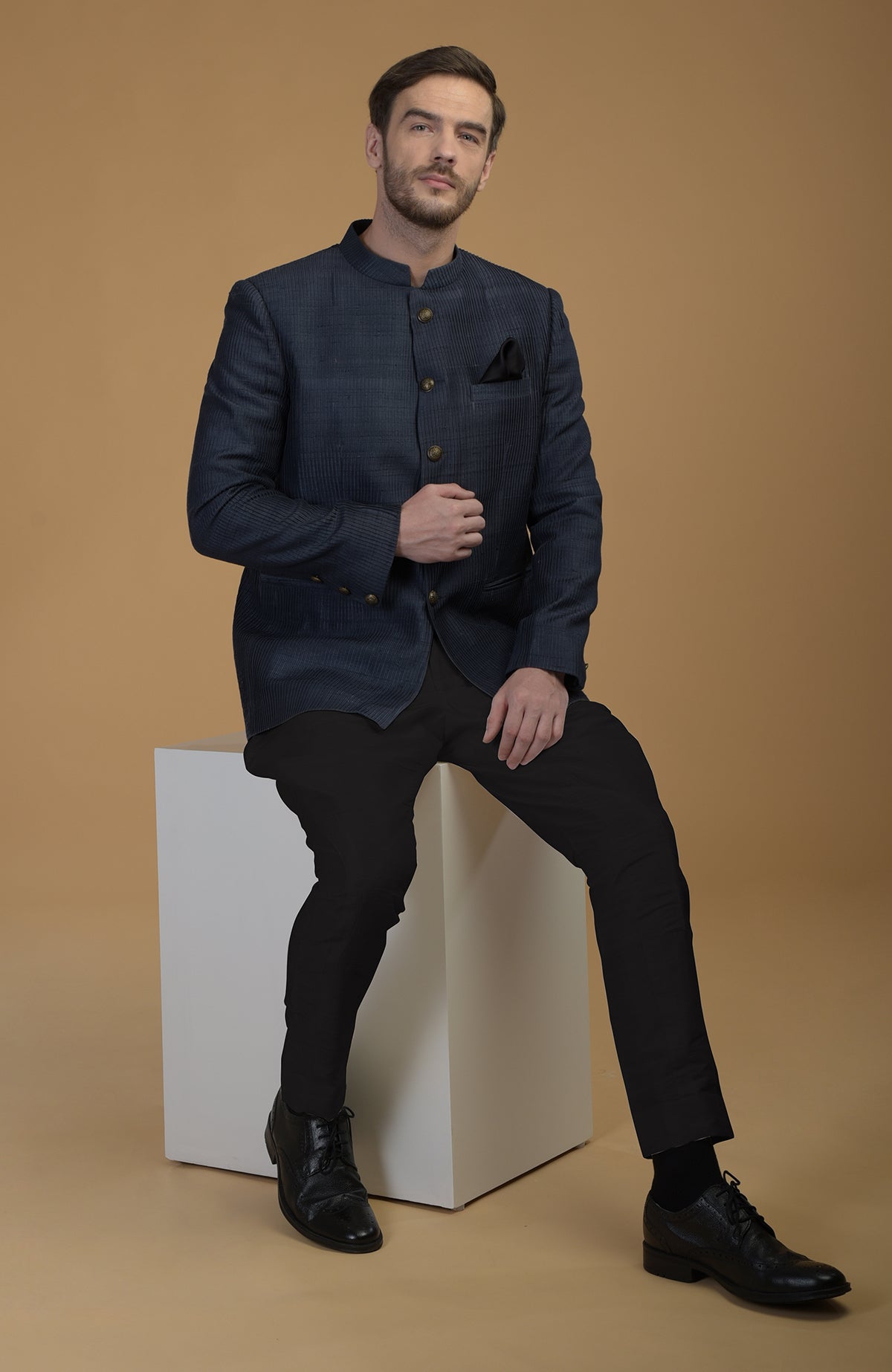 A man models an Orion Blue Pintuck Pure Raw Silk Bandhgala Jacket Set.