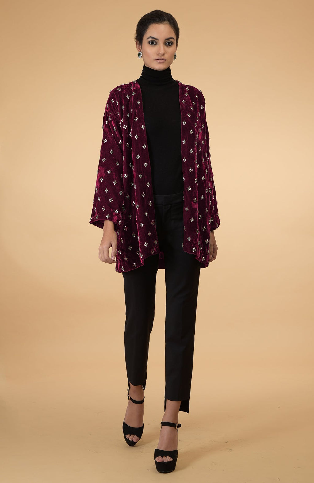 Maroon velvet jacket with crystal embroidery, black turtleneck, and black pants.