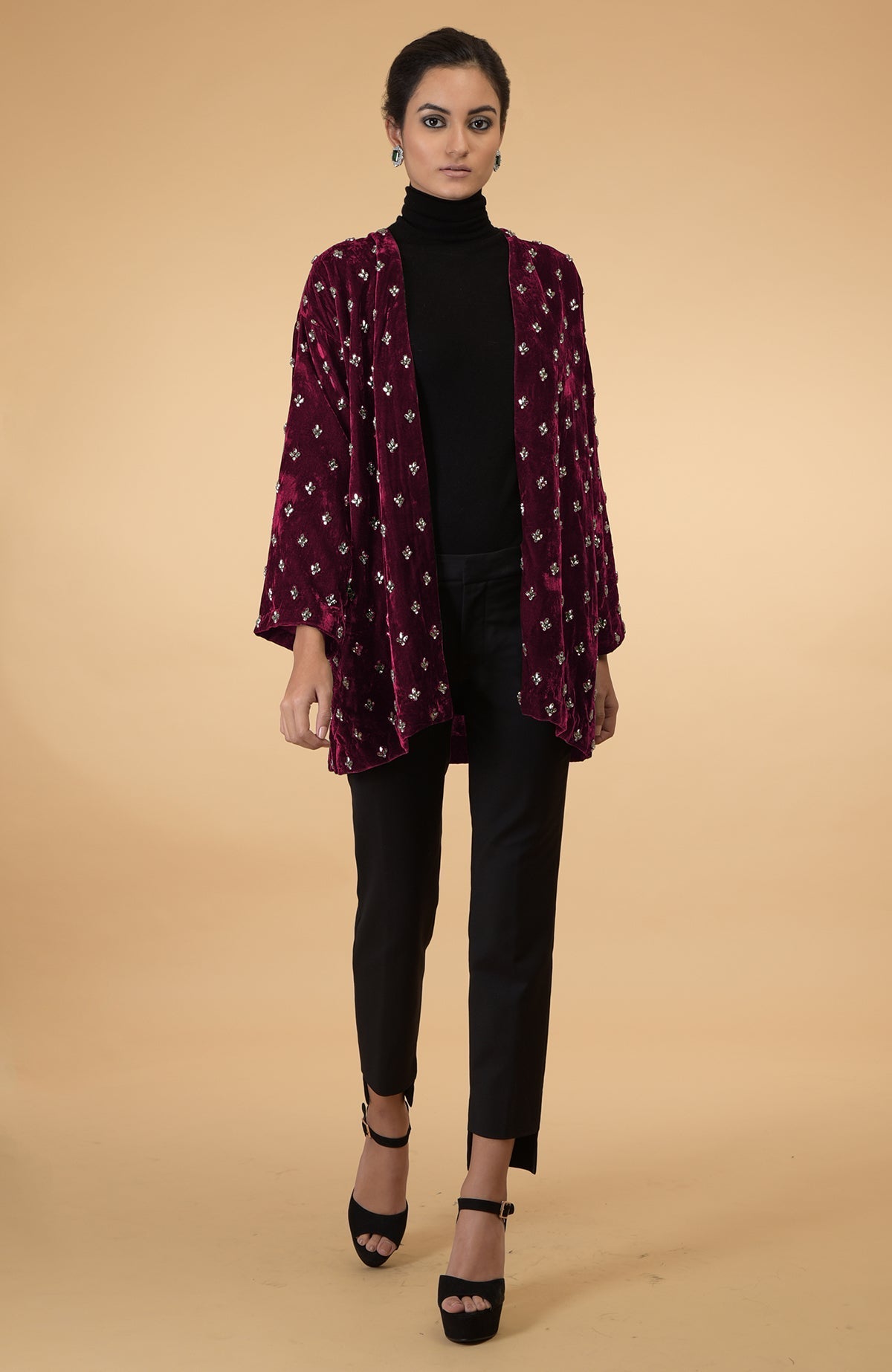 Maroon velvet jacket with crystal embroidery, black turtleneck, and black pants.
