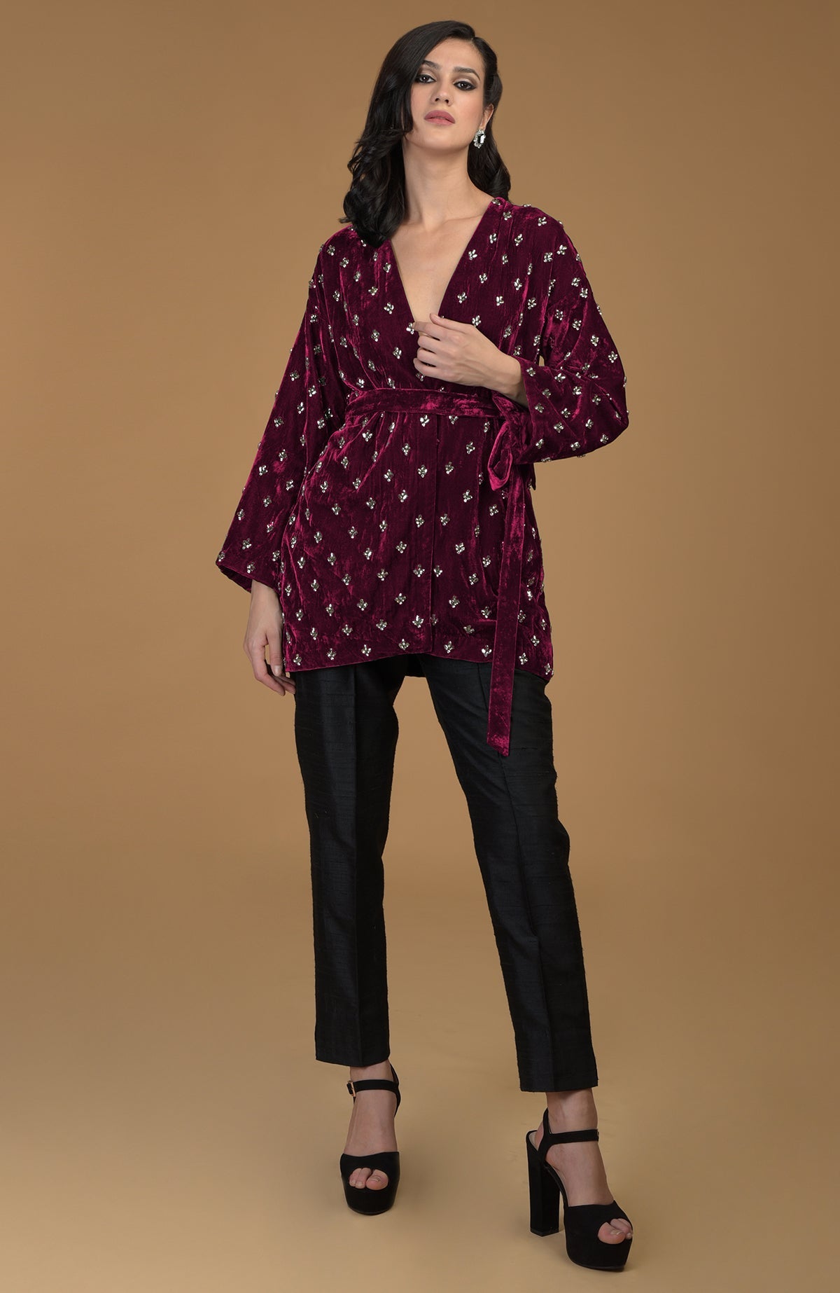 Maroon silk velvet jacket with crystal embroidery, black pants, and black platform heels.