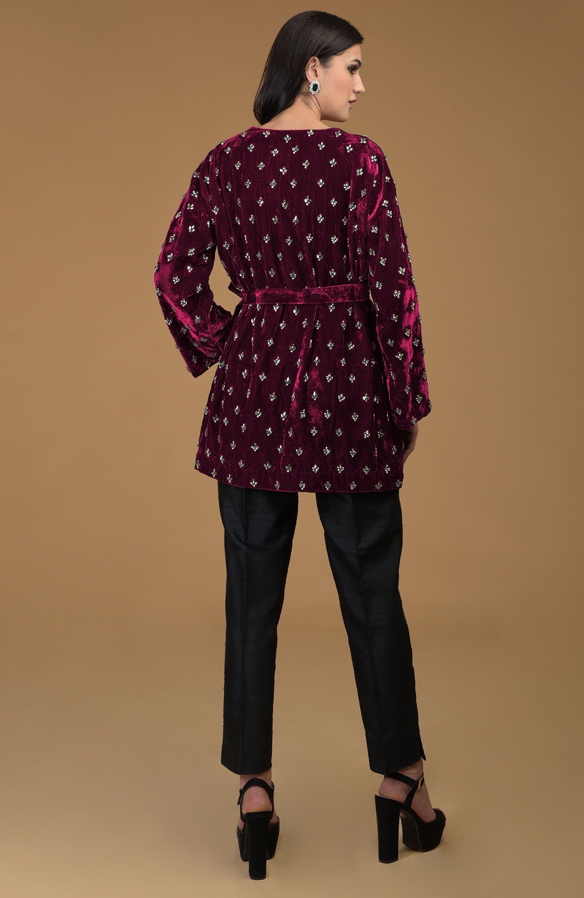 Maroon crystal hand-embroidered silk velvet jacket with a waist belt and black pants.