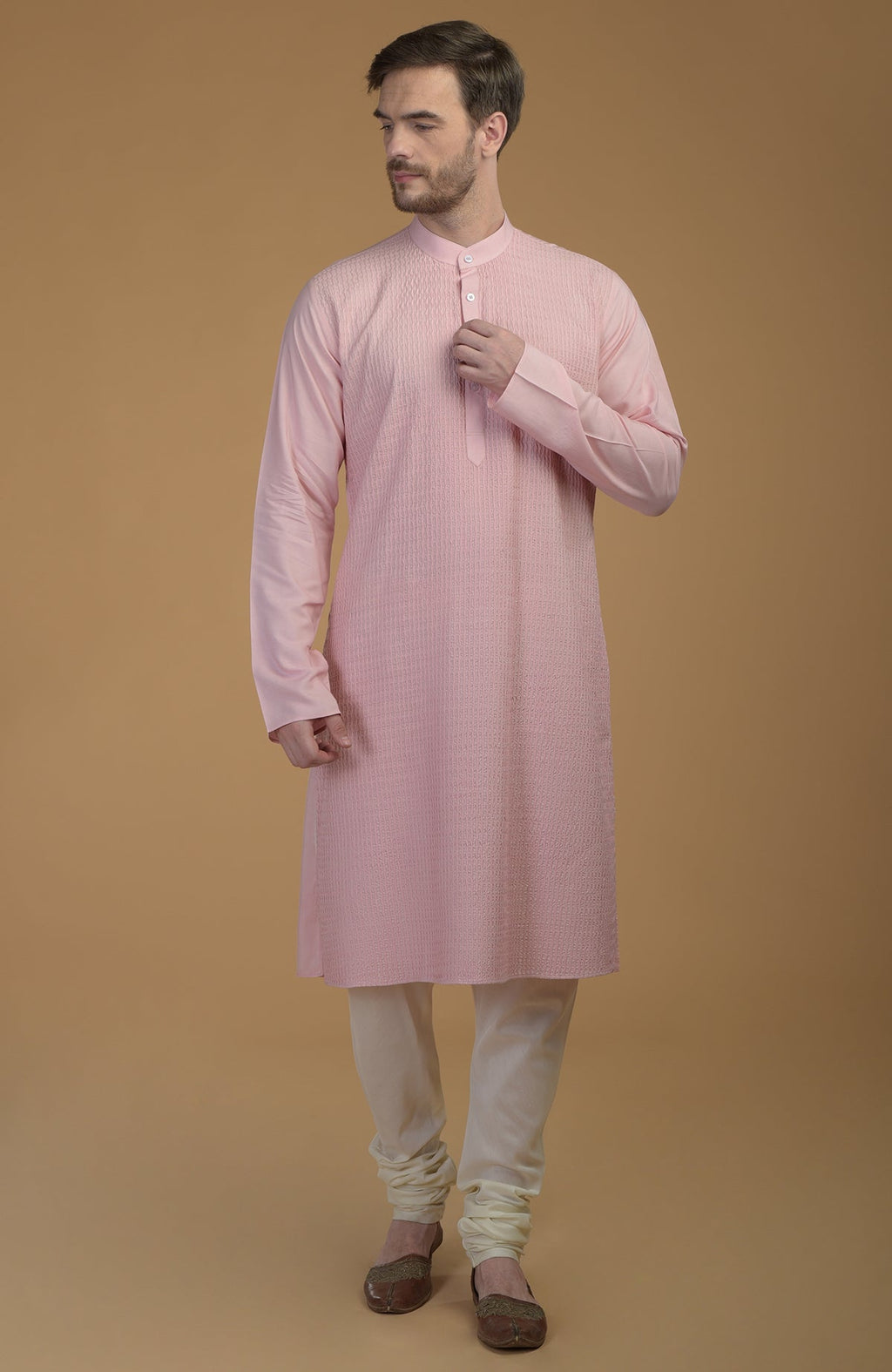 Pale pink kurta with pintuck detail, paired with ivory churidar and brown juttis.