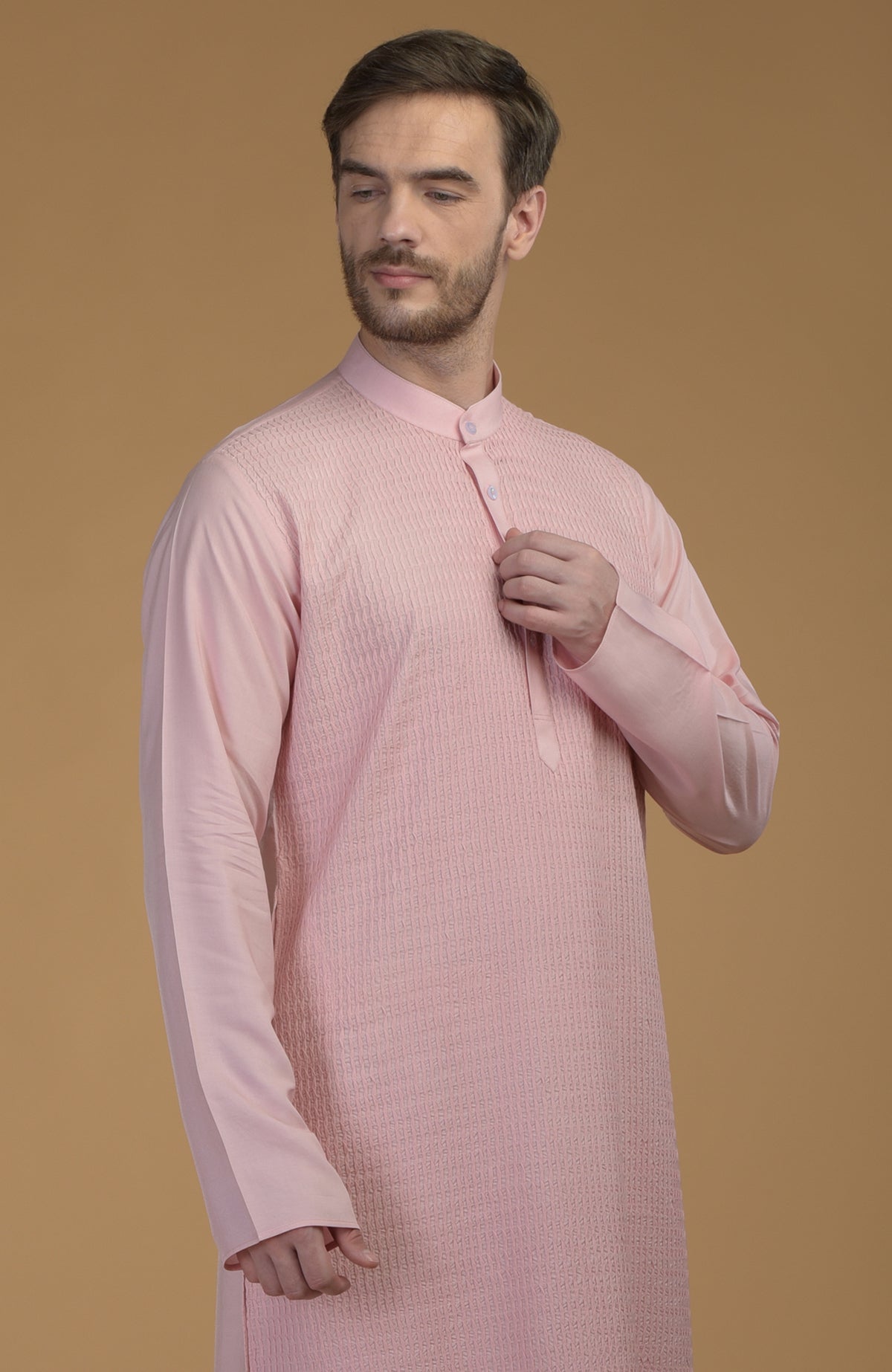 A man models a pale pink kurta with pintuck detailing.
