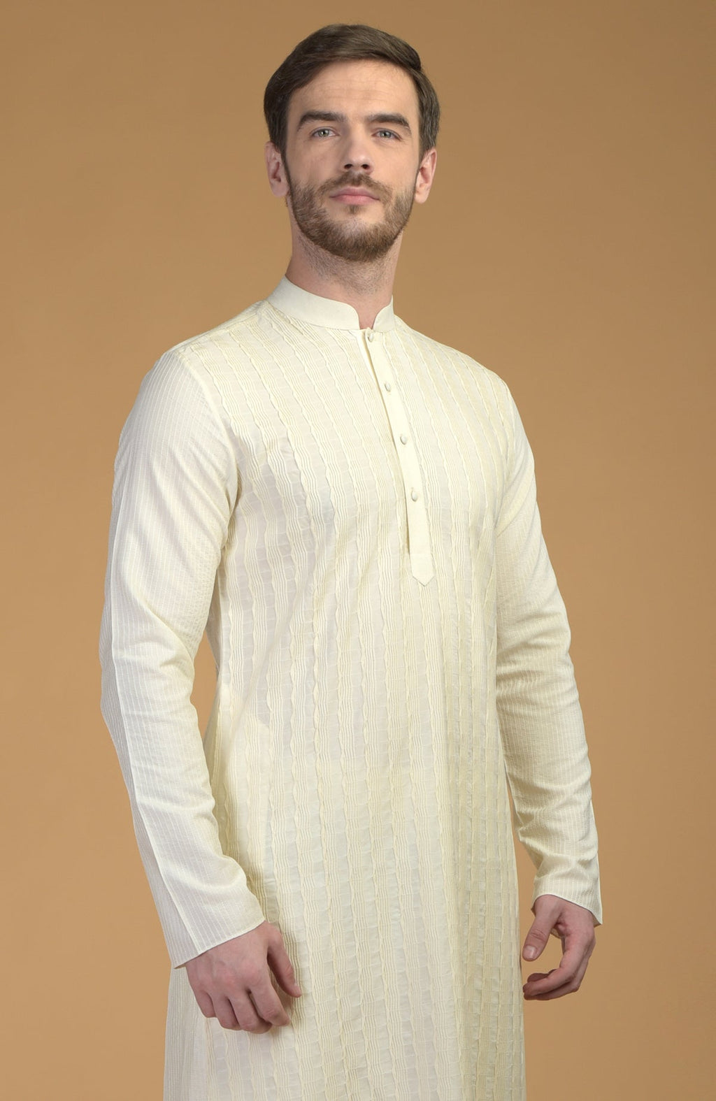 A man models a cream kurta with pintuck and kantha details.
