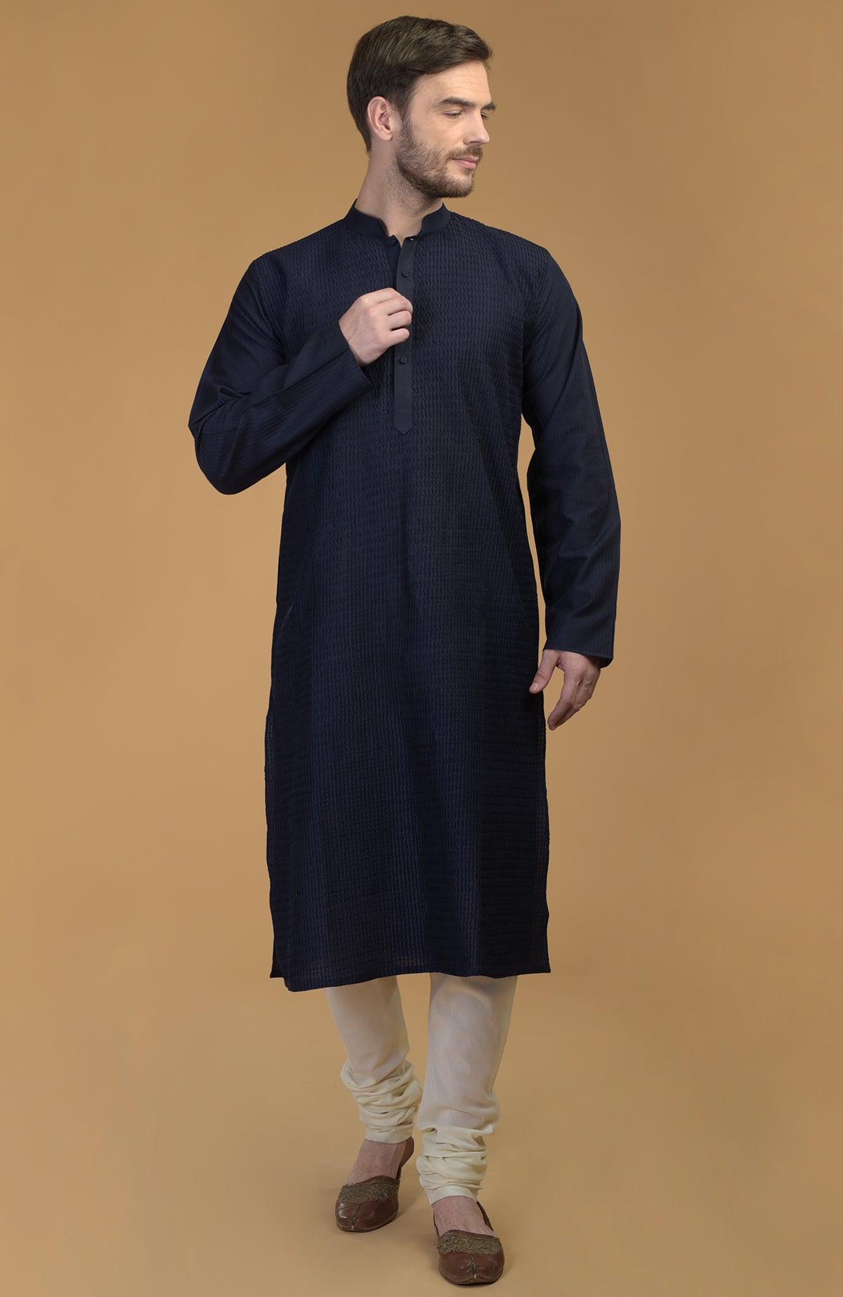 Dark navy kurta with pintuck and kantha detail, paired with ivory churidar and brown shoes.