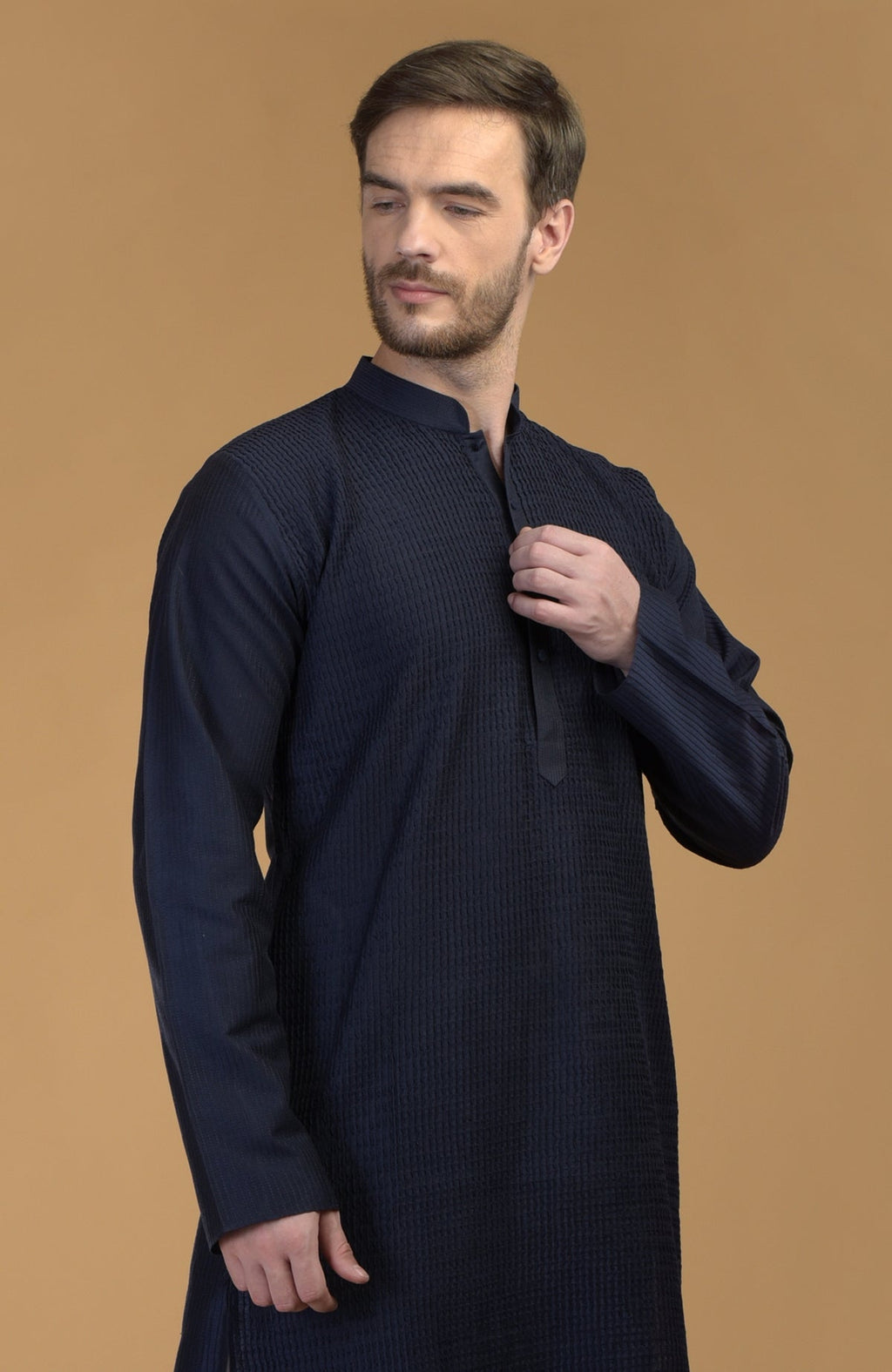 A man in a dark navy kurta with pintuck and kantha details.