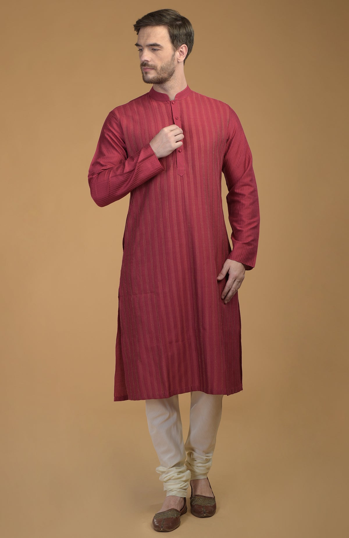 A man models a wine-colored kurta with pintuck and kantha details.