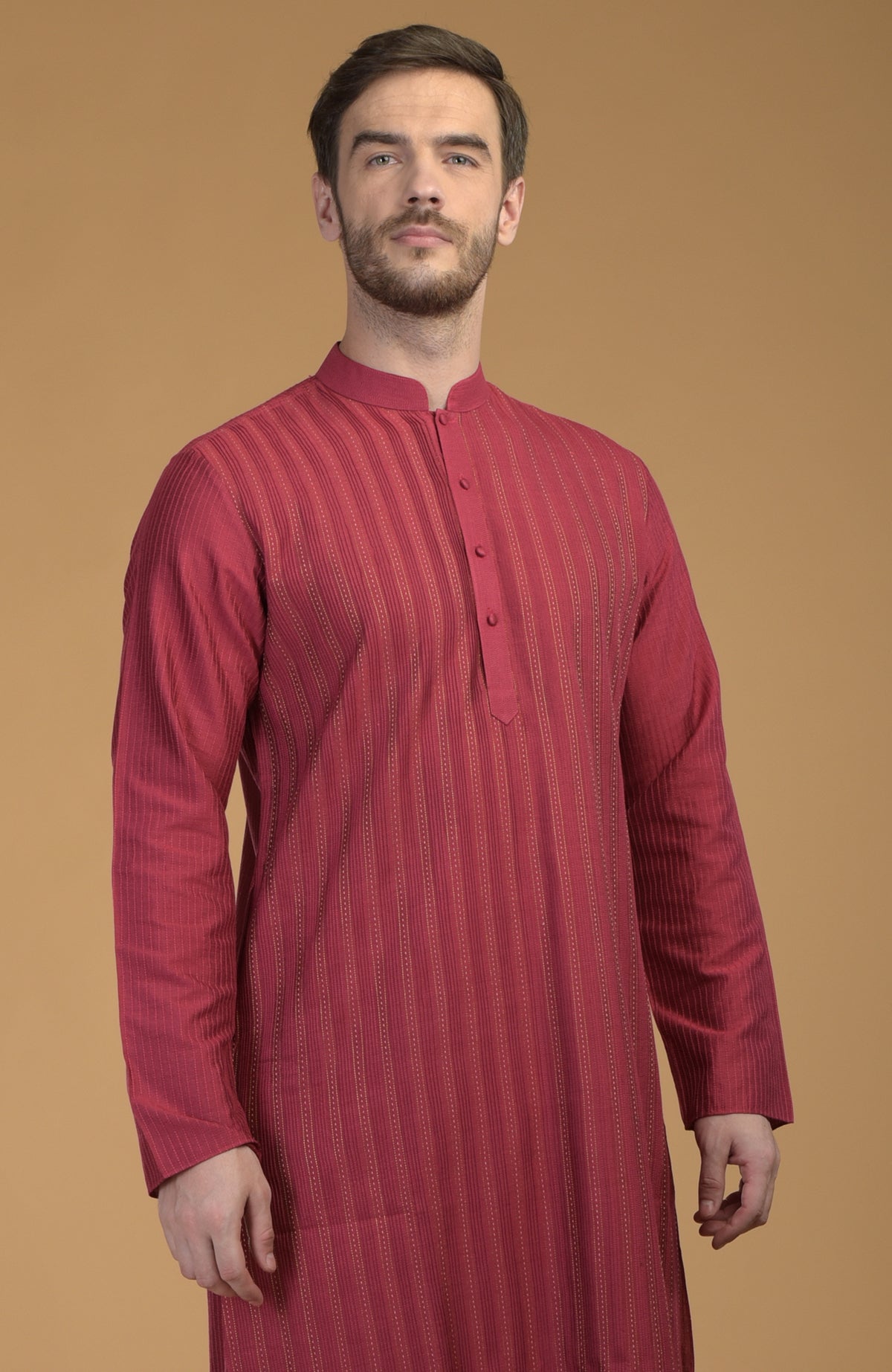 A man models a wine-colored kurta with pintuck and Kantha stitching.