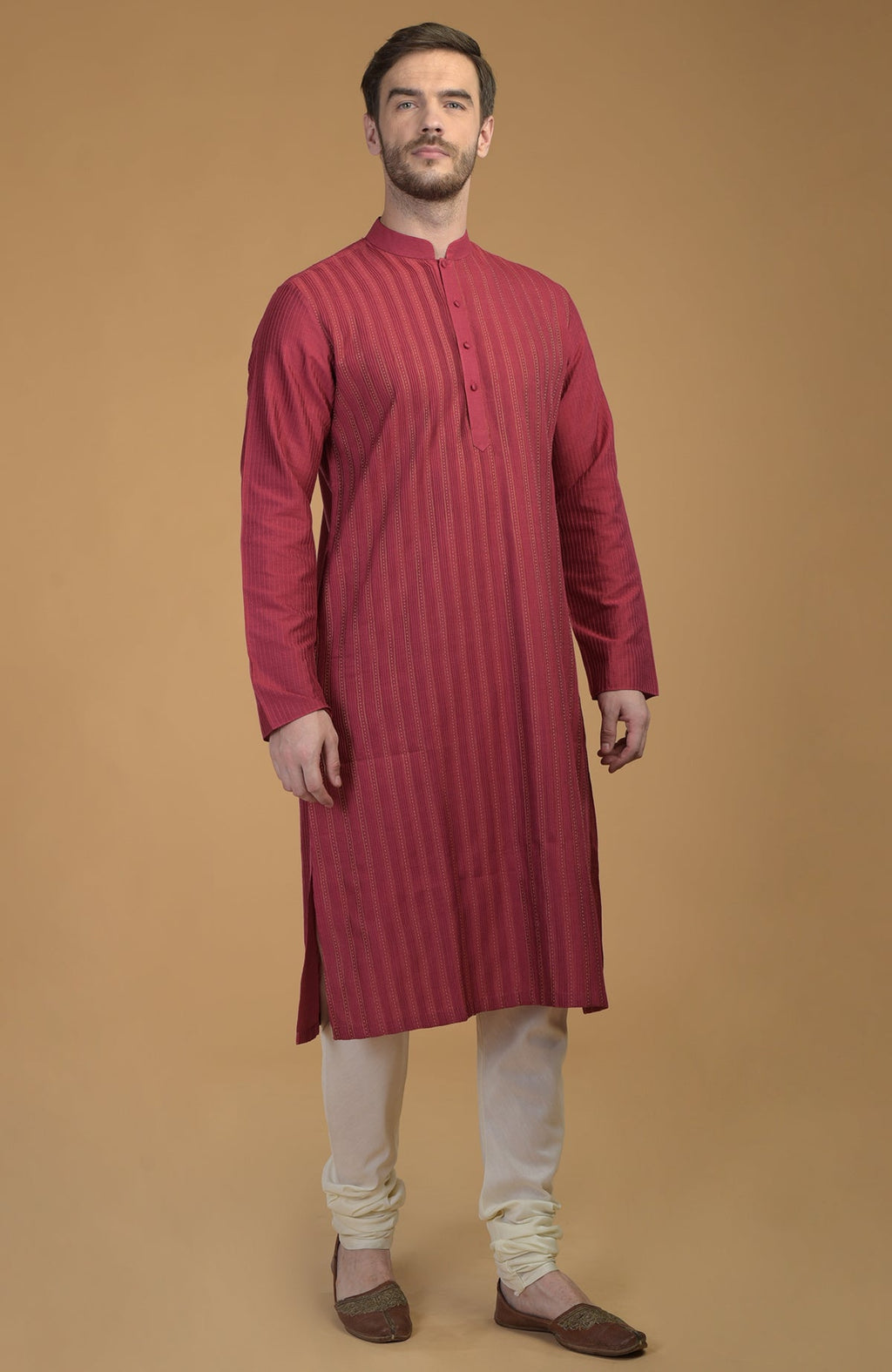 A man models a wine-colored kurta with pintuck and kantha details, paired with ivory churidars.