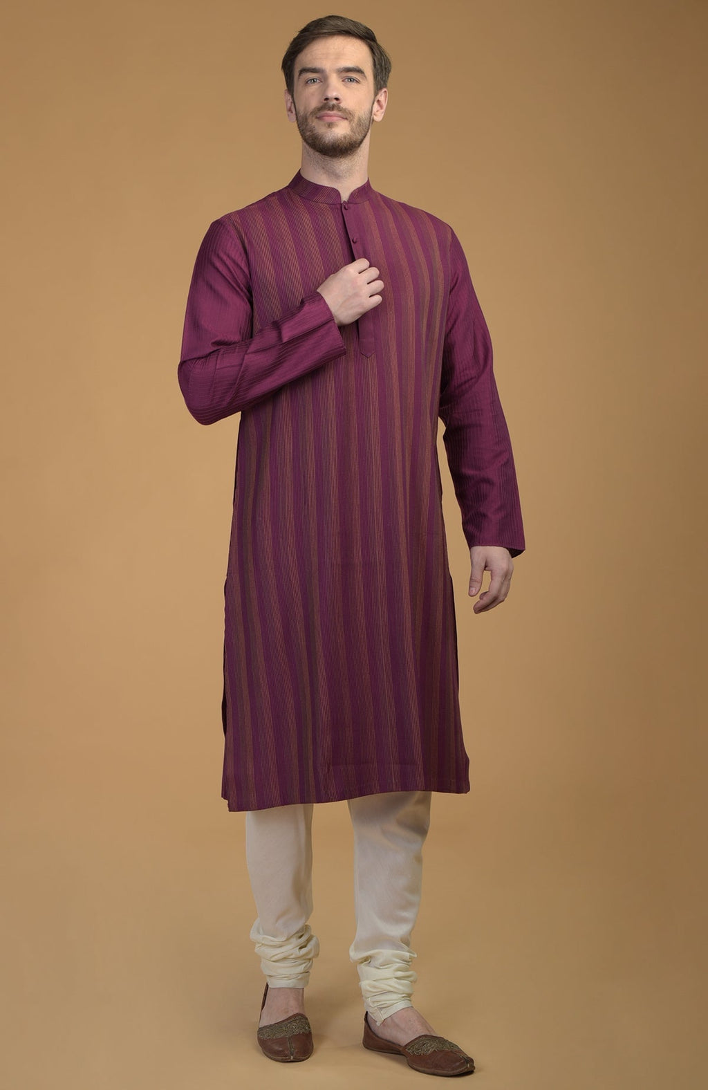 A man models a plum kurta with pintuck and kantha details and ivory churidars.
