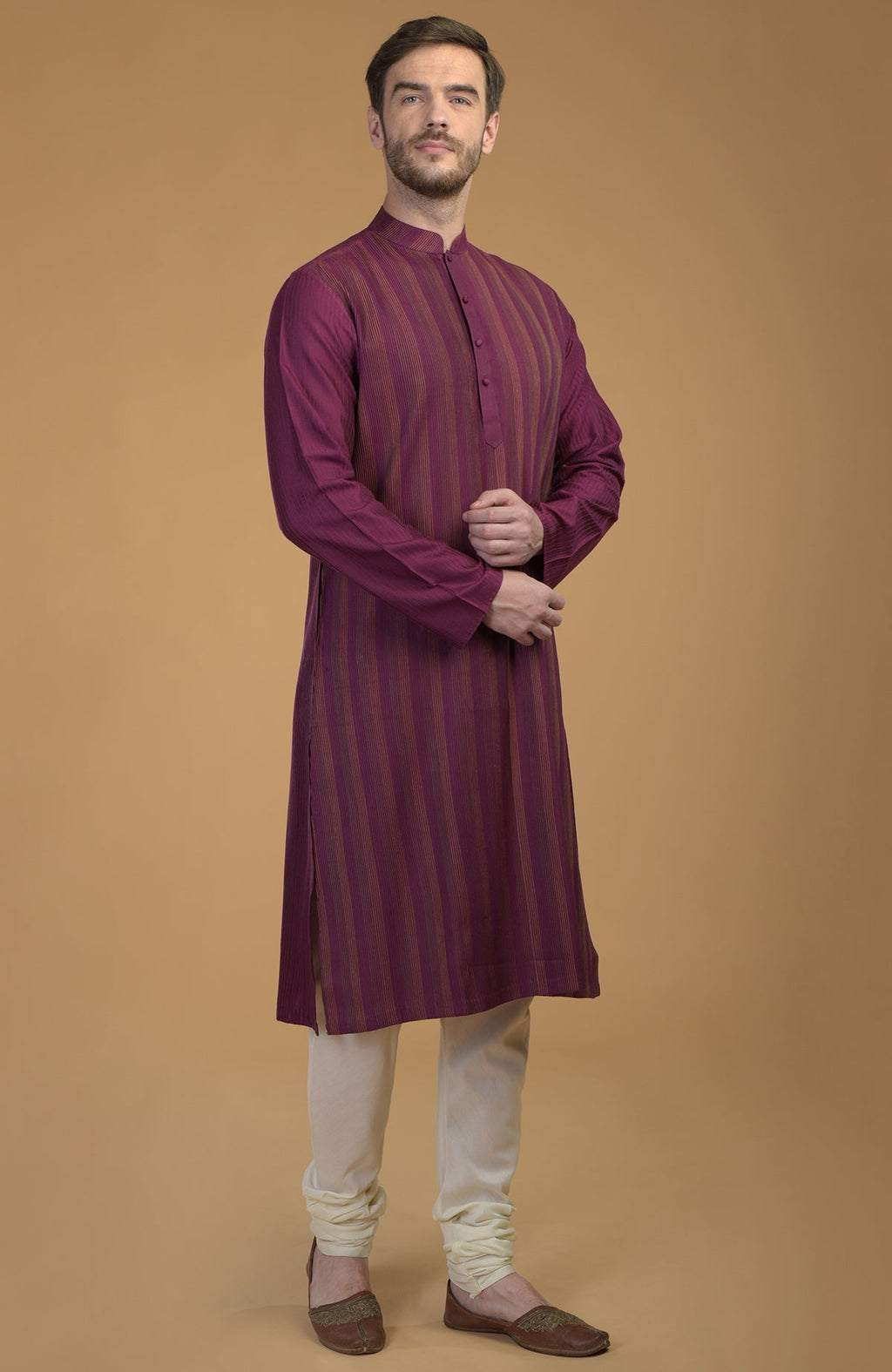 A man models a plum striped kurta with pintuck and kantha details, and ivory pants.