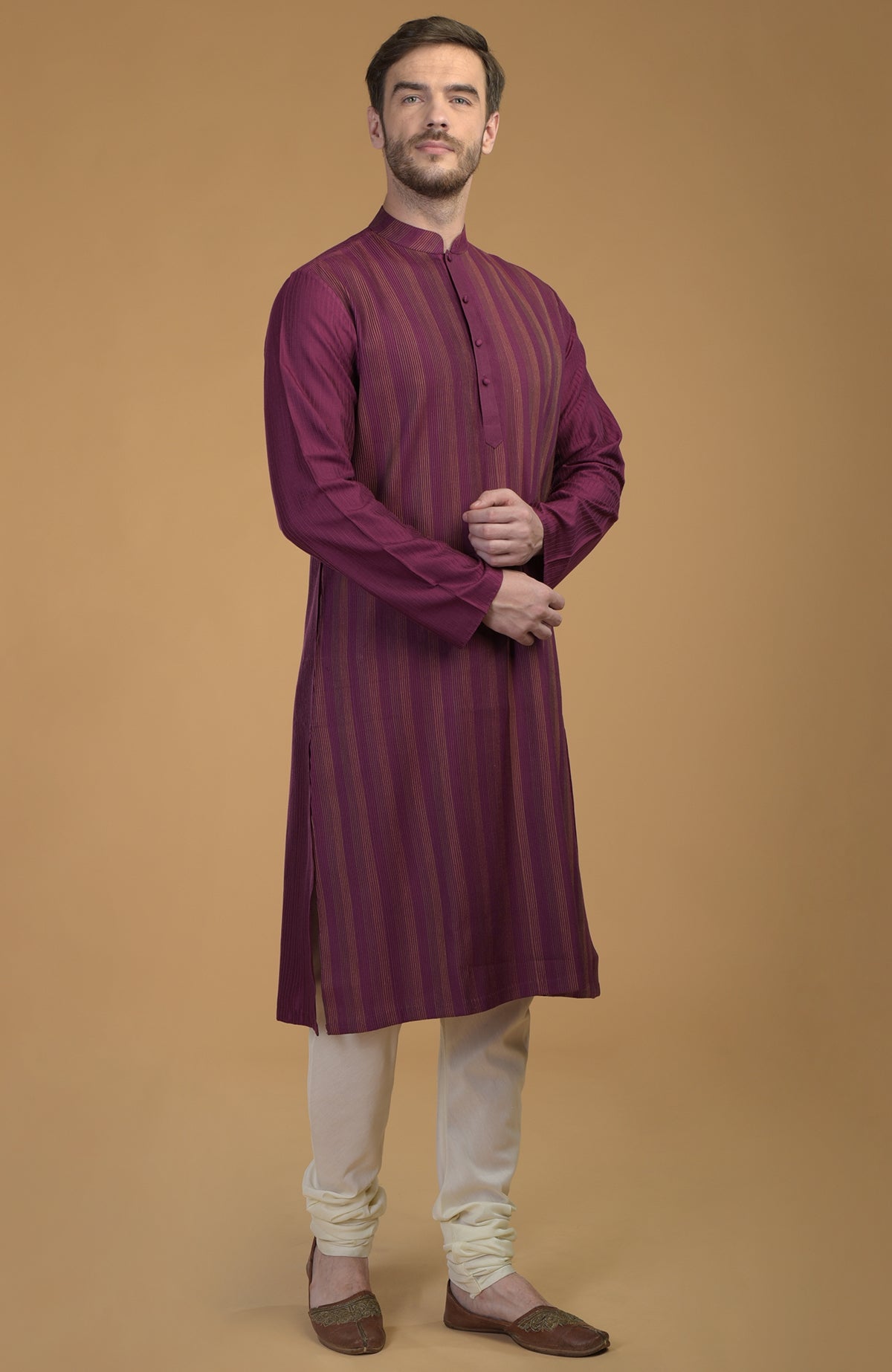 A man models a plum striped kurta with pintuck and kantha details, and ivory pants.