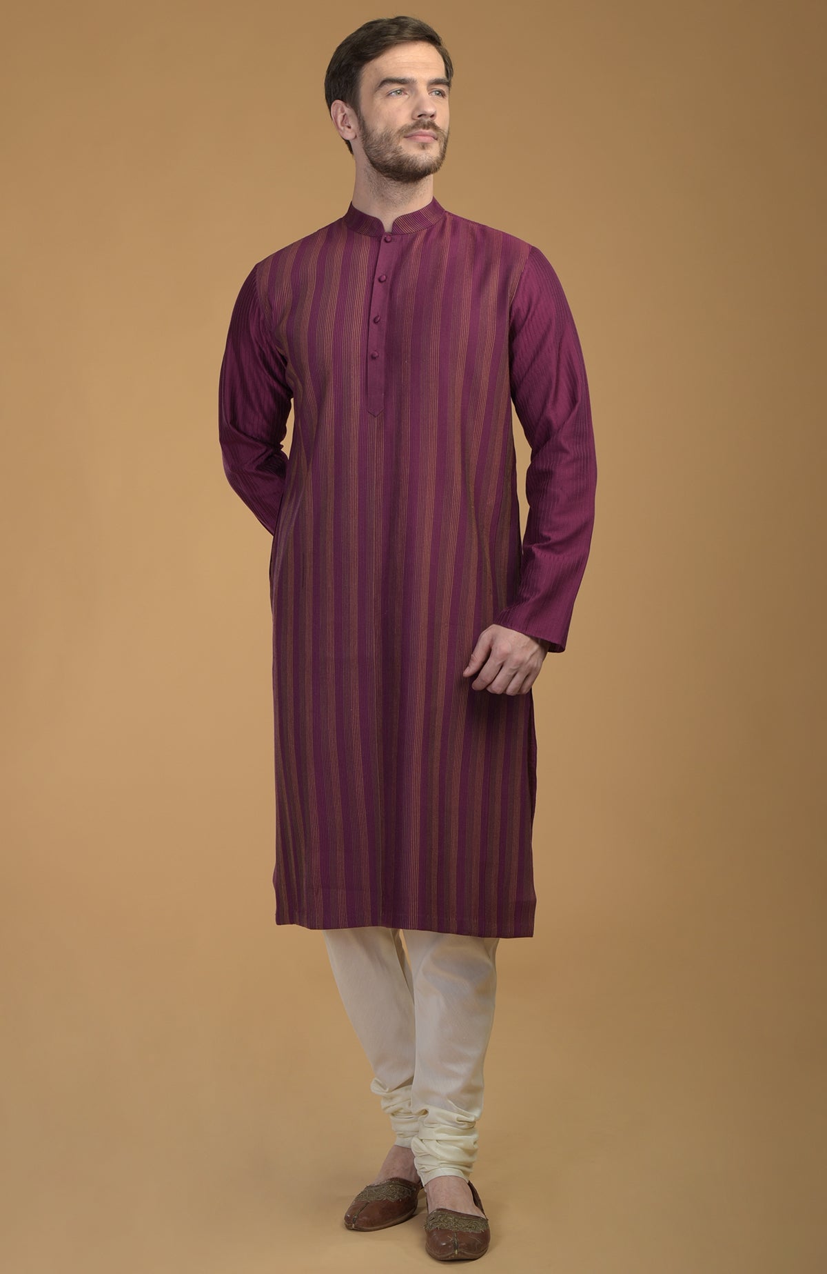 Plum kurta with pintuck and kantha detail, paired with ivory churidar and brown shoes.