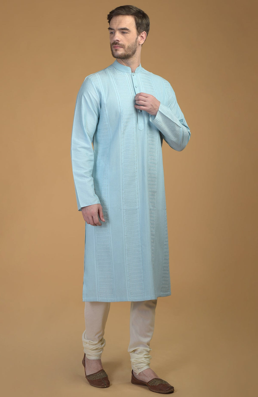 An ice blue kurta with pintuck and Kantha details, paired with ivory churidar pants.