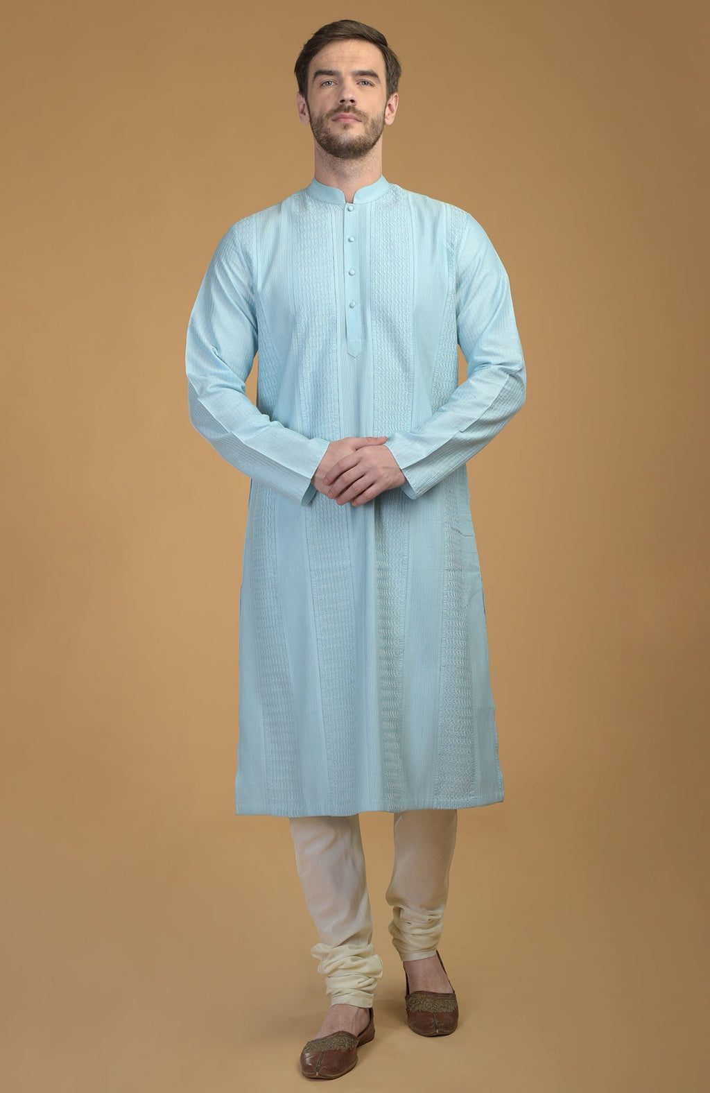 Ice blue kurta with pintuck and kantha detail, paired with ivory churidar and brown juttis.
