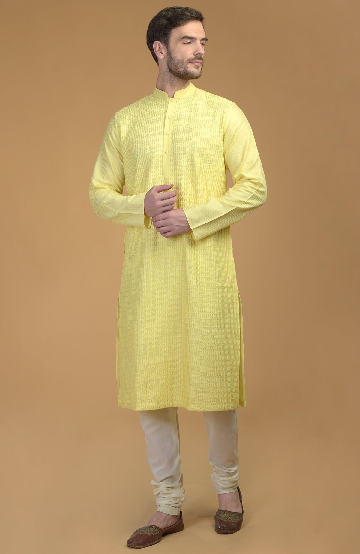 A man models a lemon yellow kurta with pintuck and kantha details, and ivory churidars.