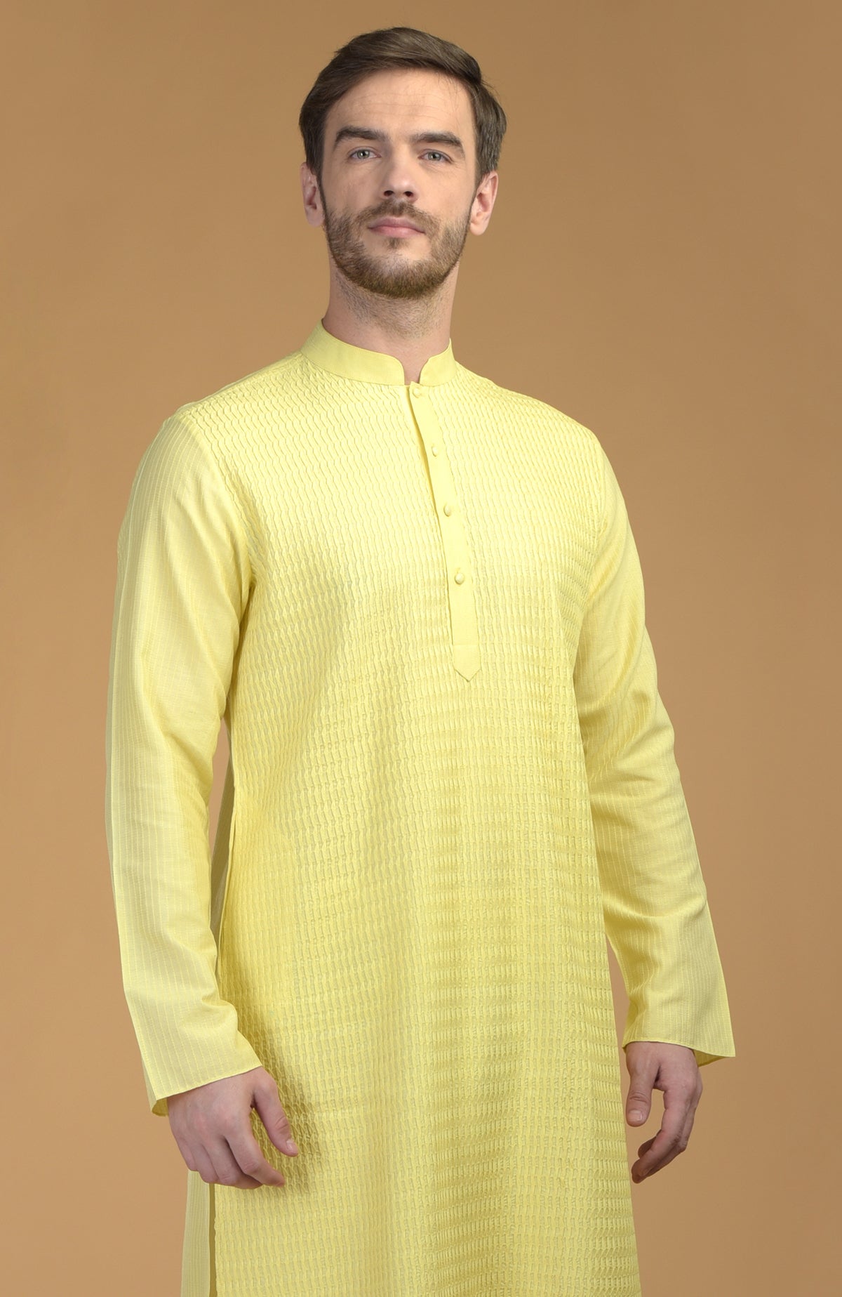 A man models a lemon yellow kurta with pintuck and kantha details.