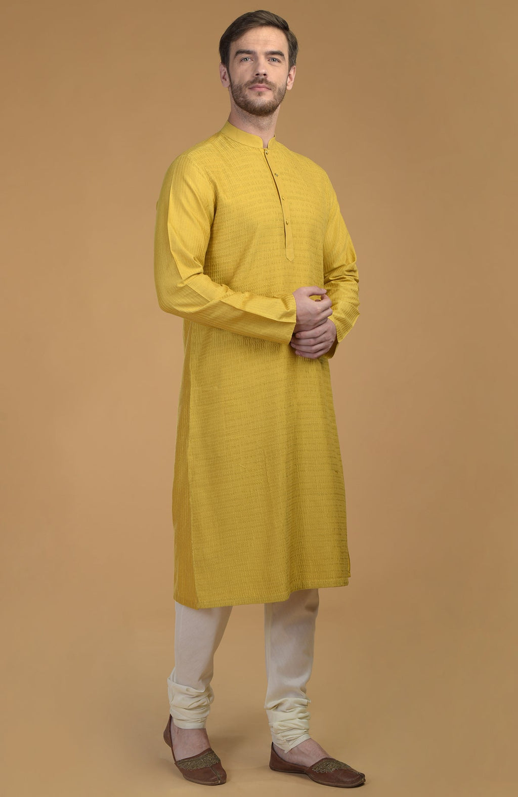 Sunglow yellow kurta with pintuck and kantha detail, paired with ivory churidars.