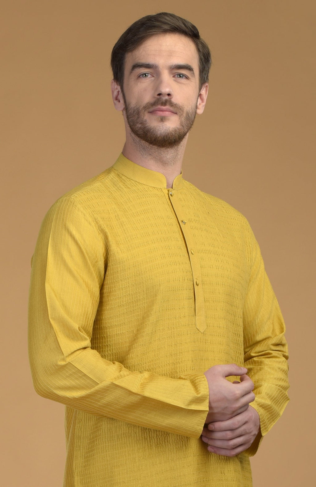 A man in a sunglow yellow kurta with pintuck and kantha detail.