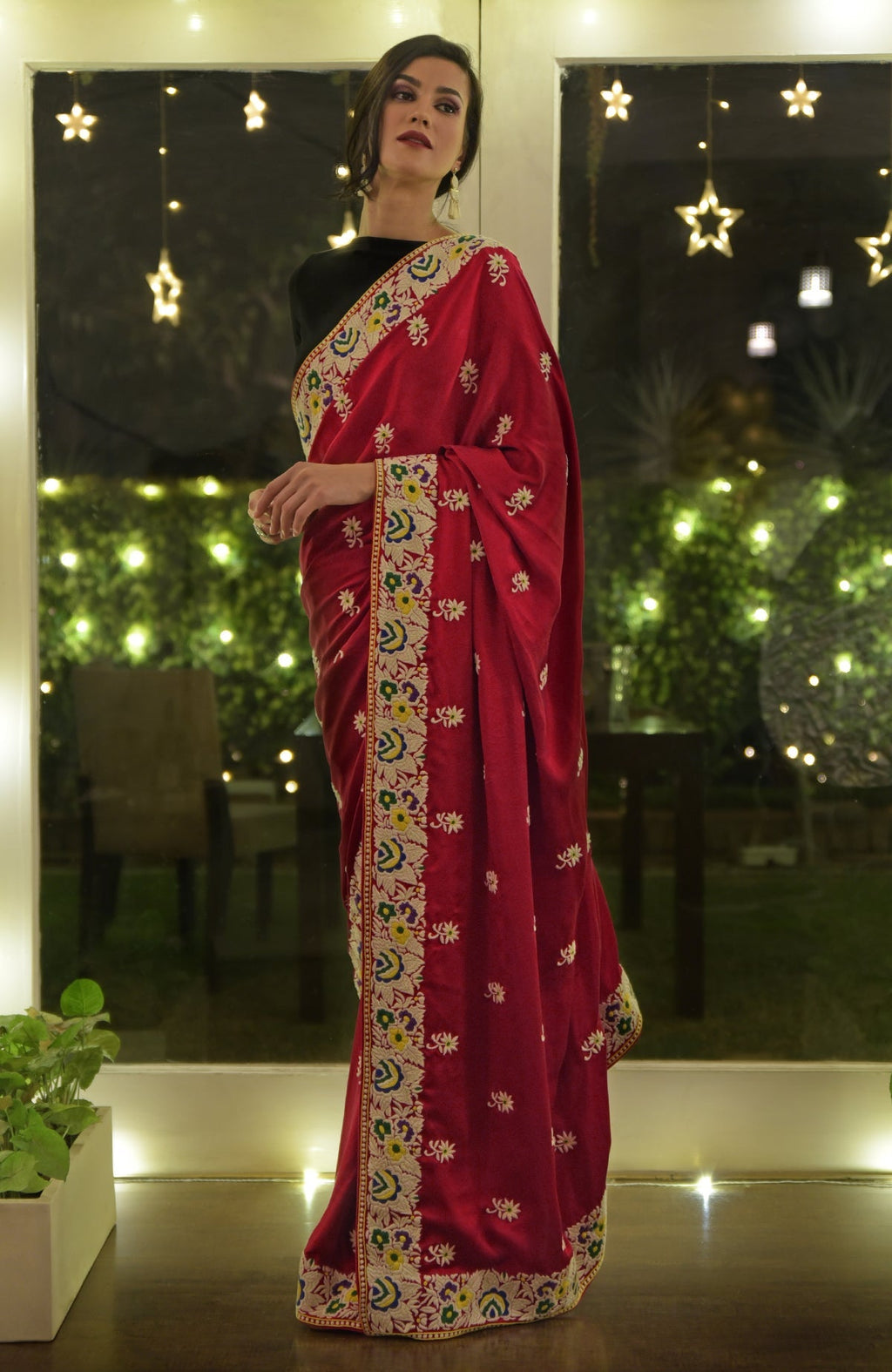 A woman models a red Parsi Gara hand-embroidered saree with intricate floral patterns.