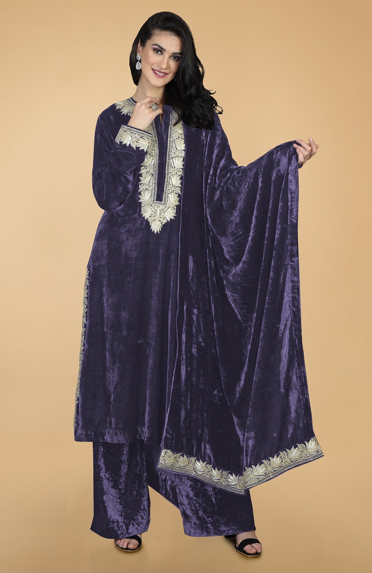 A woman models a midnight blue silk velvet kurta set with Kashmiri tilla embroidery.