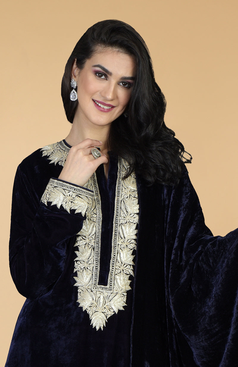A woman models a midnight blue velvet kurta with silver Kashmiri tilla embroidery.