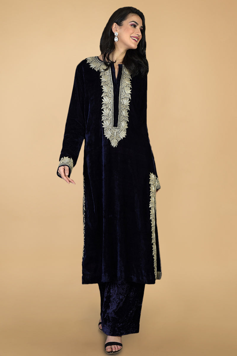 A woman models a midnight blue silk velvet kurta set with silver Kashmiri tilla embroidery.