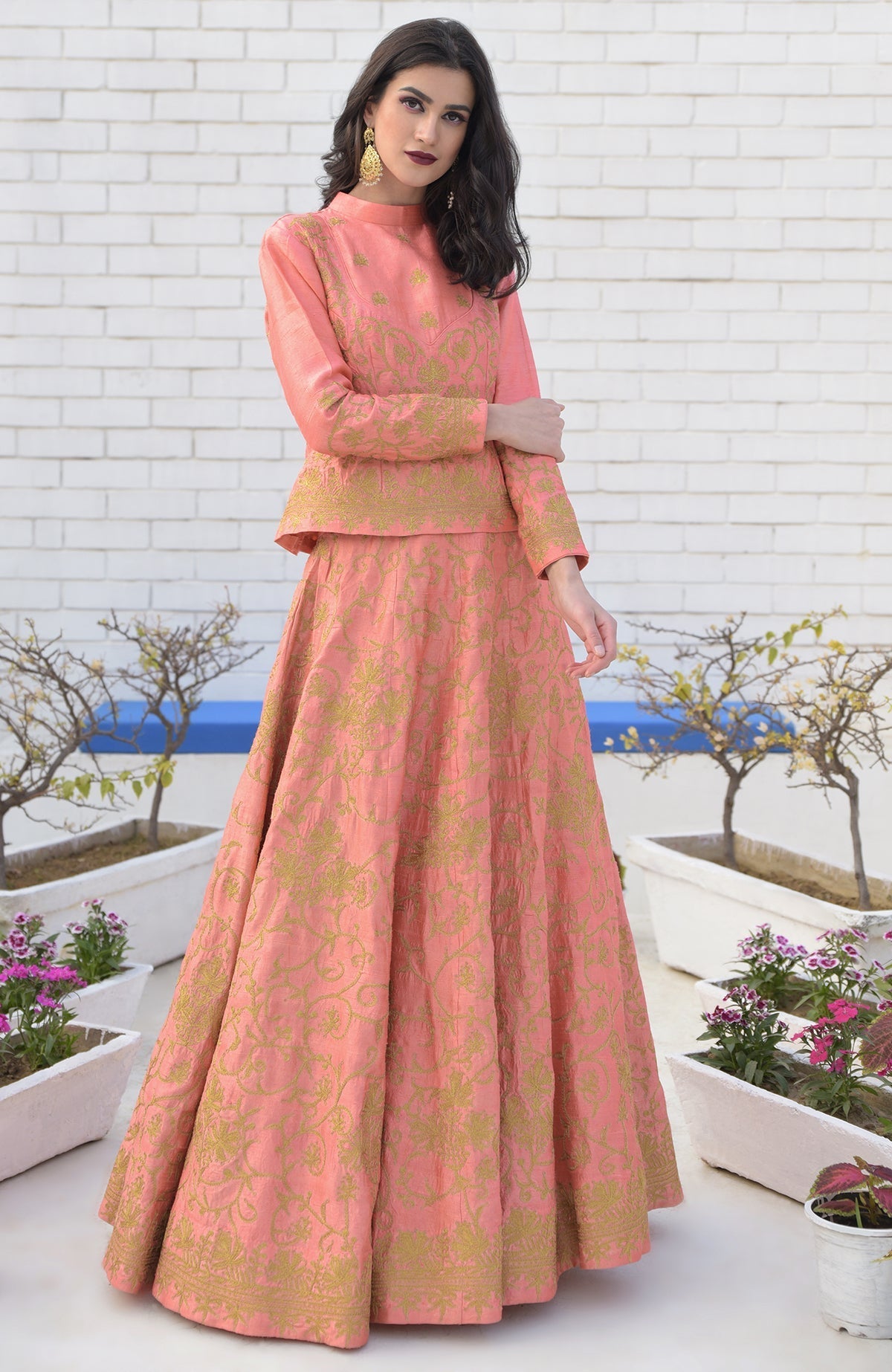 A woman models a peach echo Kashmiri chinar tilla embroidered lehenga set.