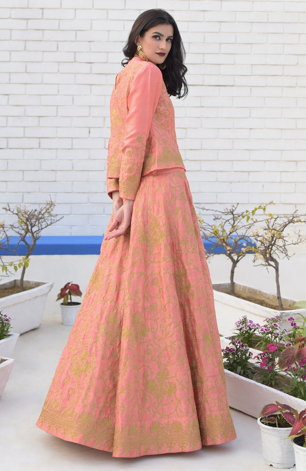 A woman models a peach echo Kashmiri chinar tilla embroidered lehenga set.