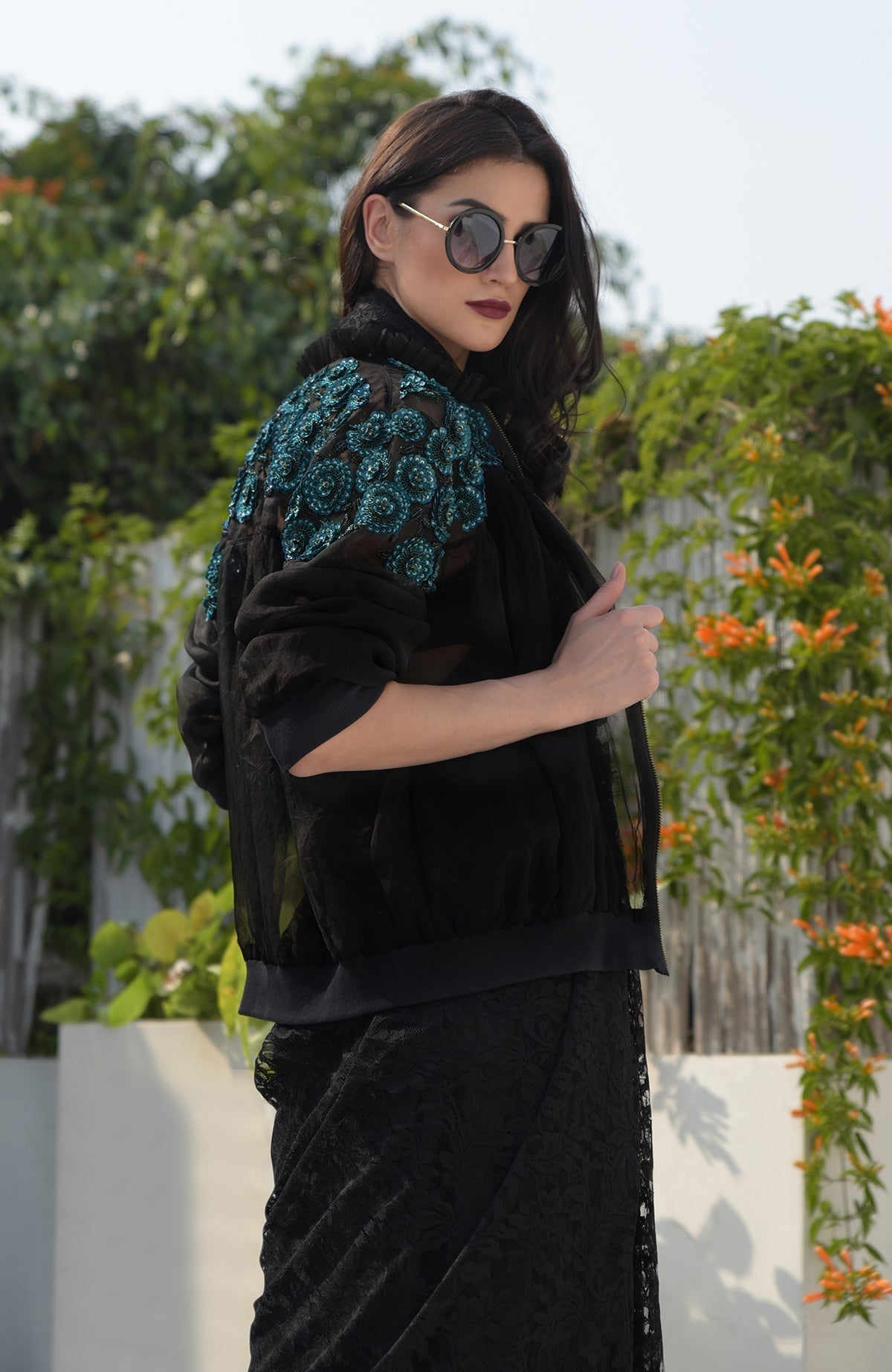 Black organza bomber jacket with blue 3D floral hand embroidery and ribbed cuffs and hem
