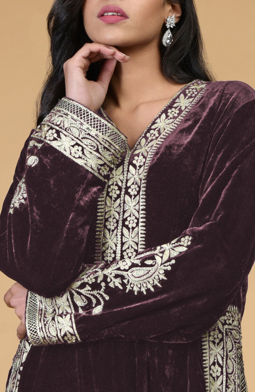 A woman models a mulled wine velvet kurta with silver tilla embroidery.