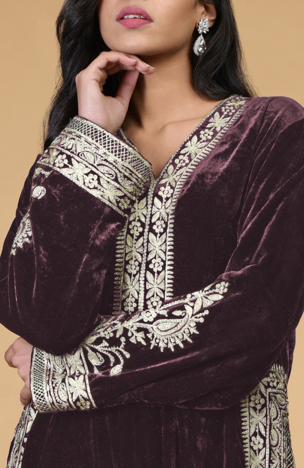 A woman models a mulled wine velvet kurta with silver tilla embroidery.