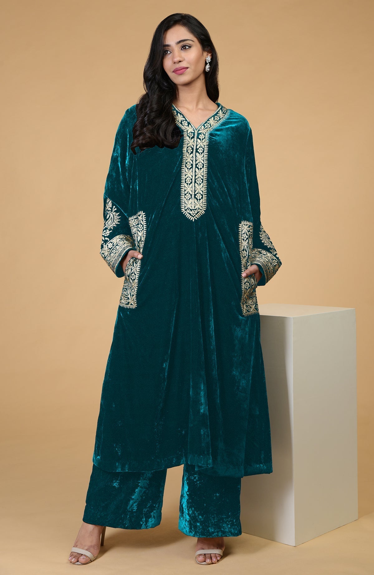 Teal velvet kurta set with Kashmiri tilla embroidery on the neckline, pockets, and sleeves.