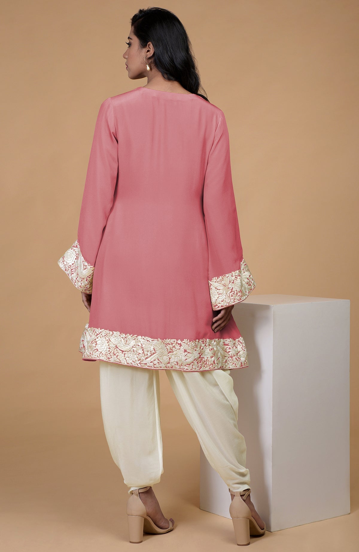A woman models a flamingo pink Parsi Gara embroidered Patiala pants suit.