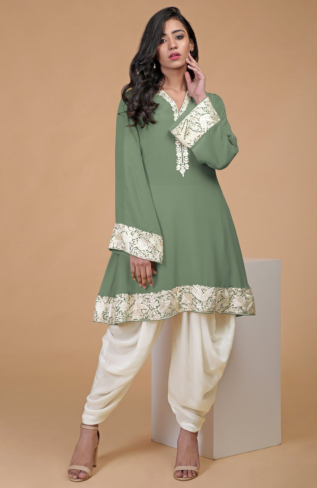 A woman models a green Parsi Gara embroidered Patiala pants suit with ivory cowl pants.