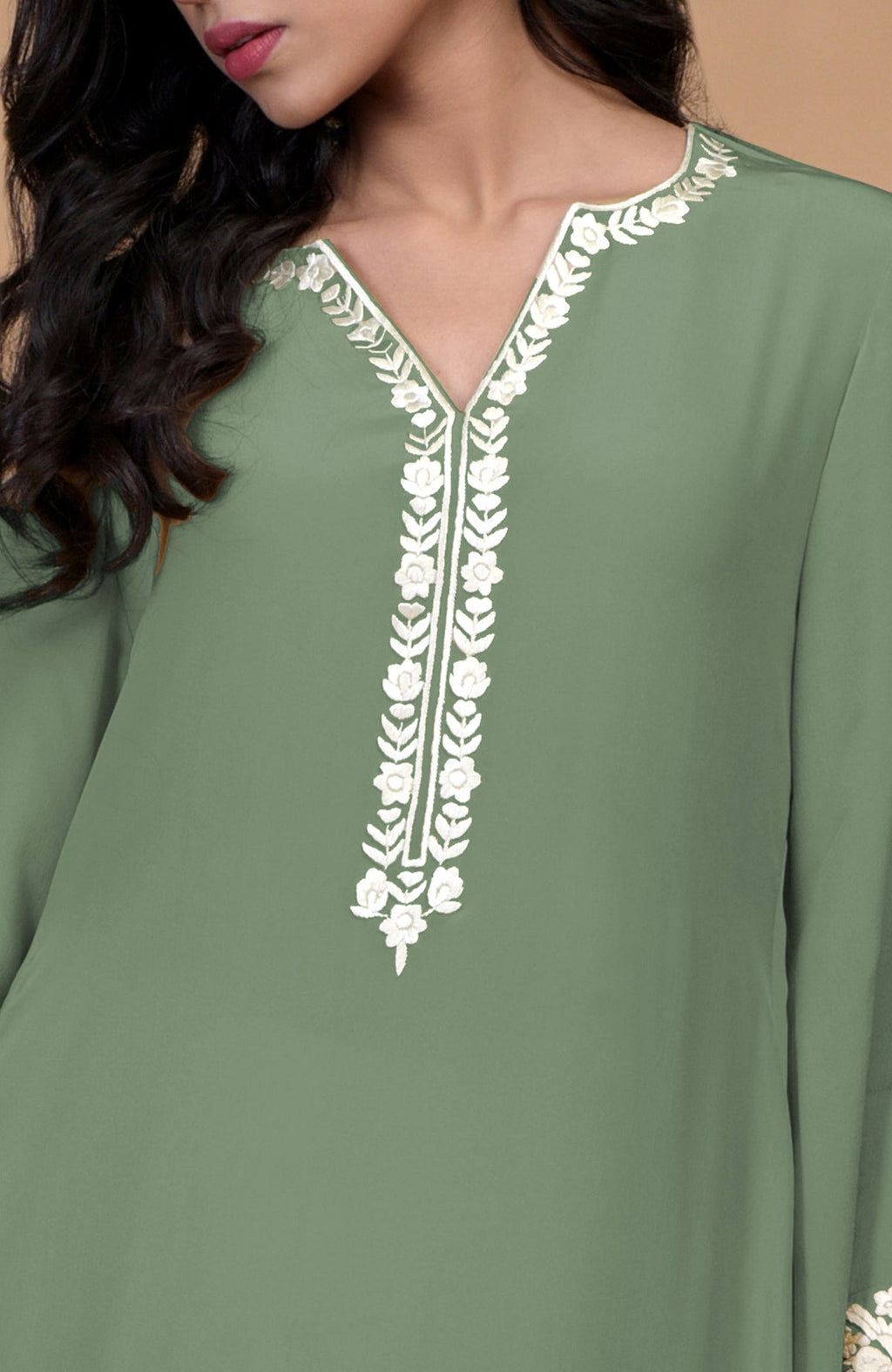 A woman wears a sage green Parsi Gara embroidered Patiala pants suit.