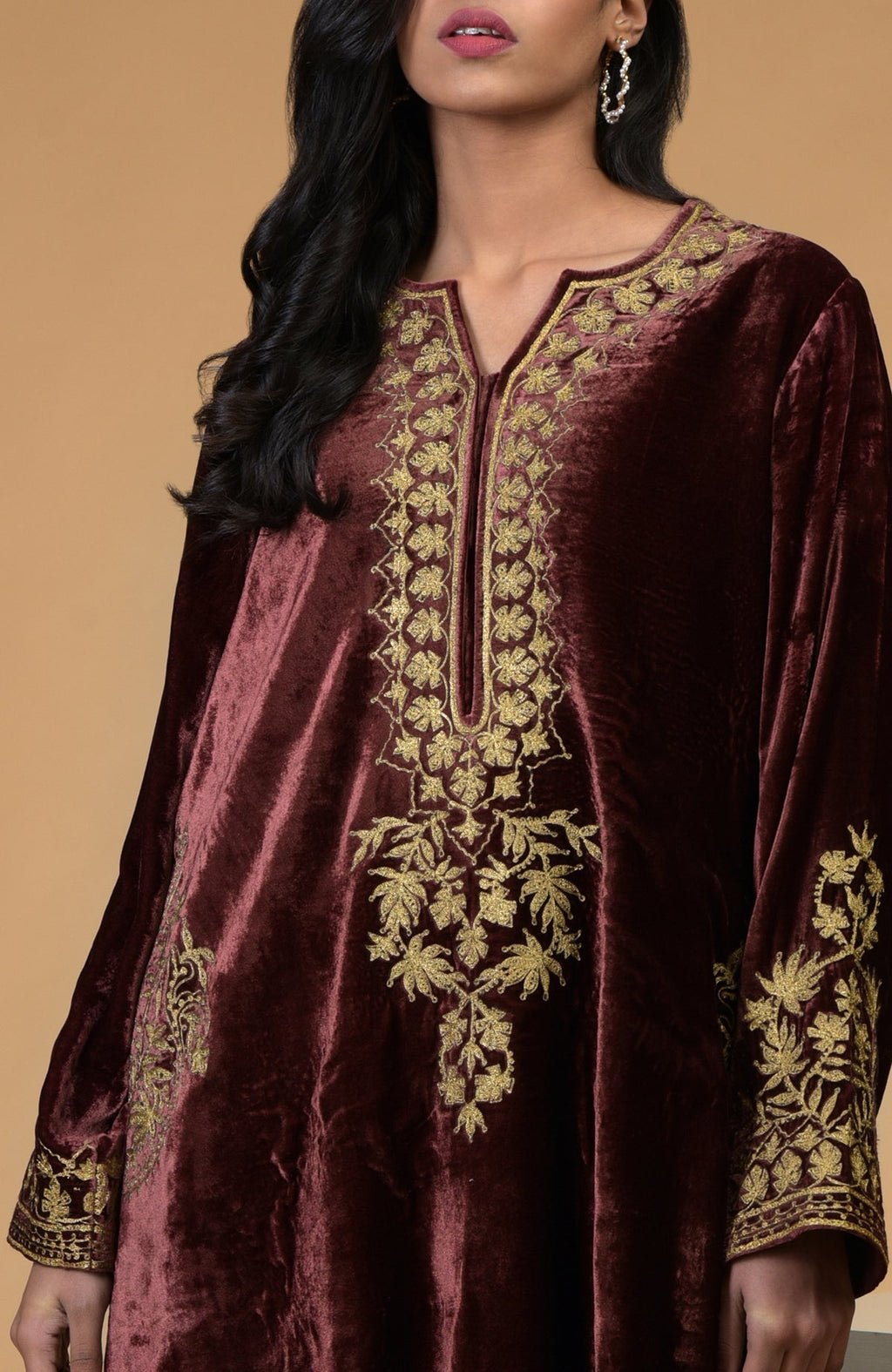 A woman models a rusty rose velvet kurta with gold Kashmiri tilla aari embroidery.