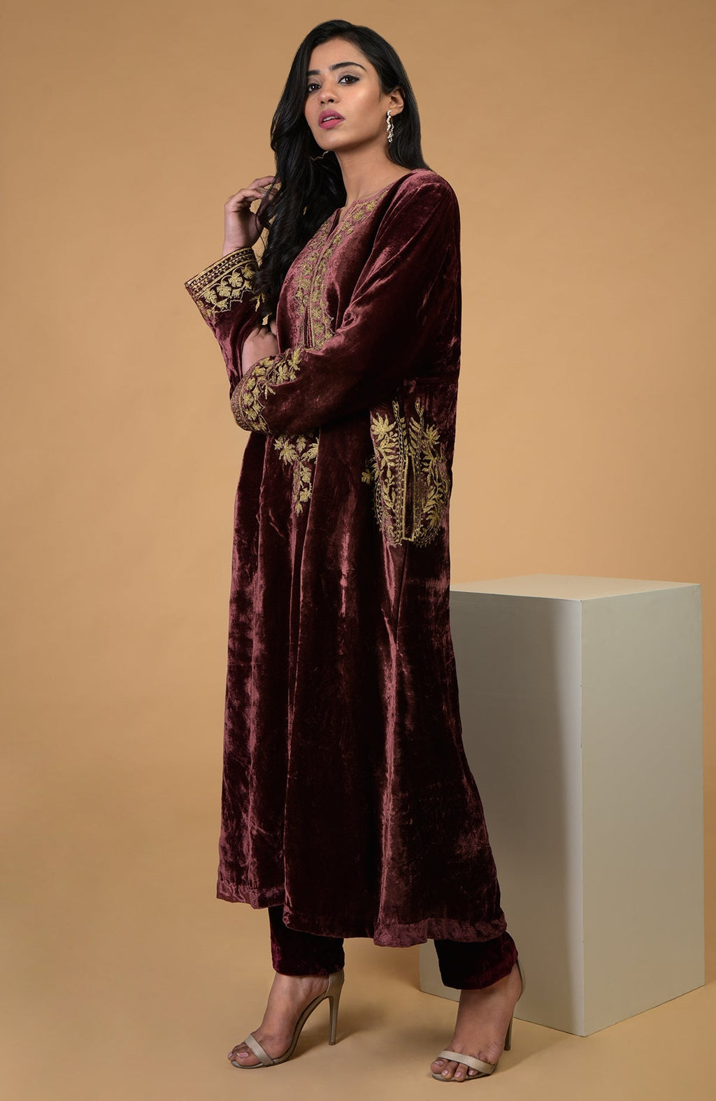 A woman models a rusty rose Kashmiri Tilla Aari embroidered choga kurta set.