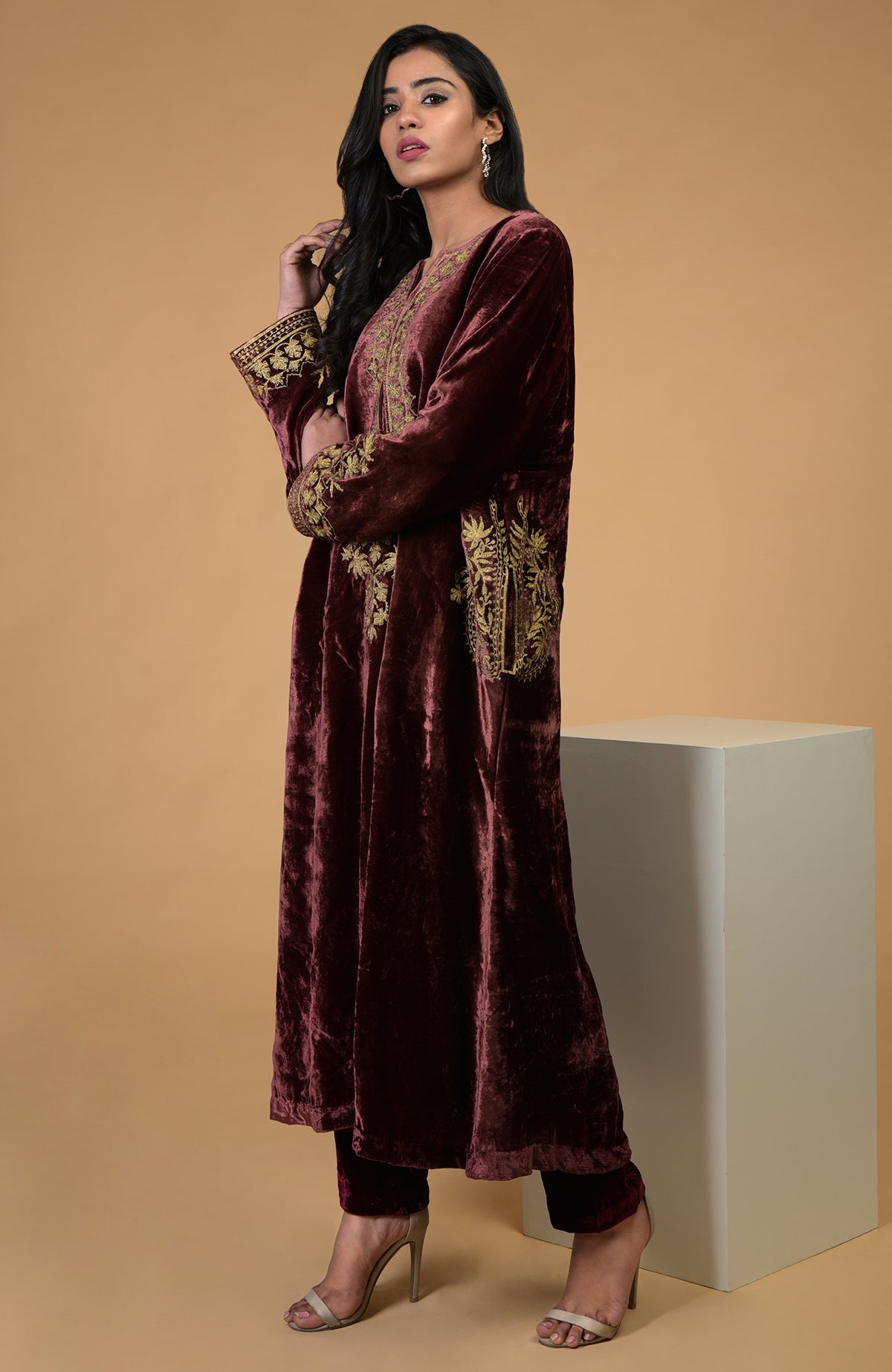 A woman models a rusty rose Kashmiri Tilla Aari embroidered choga kurta set.